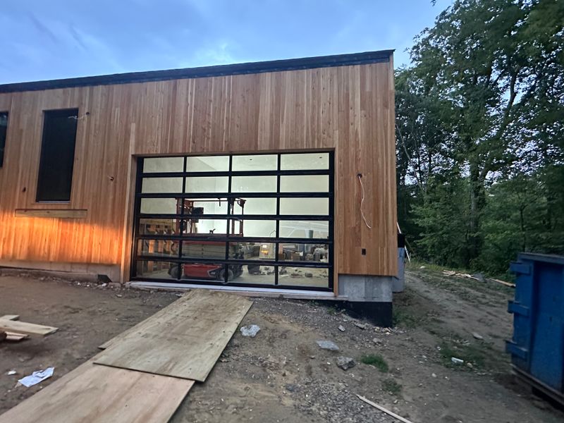 Modern full-view glass garage door on a Massachusetts home